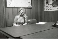 Penny Williams, Volunteer, sits at a table in an office