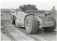 1979  Back view of Caterpillar 613 earthmoving machine filled with dirt