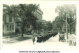 Commencement procession walking north on Capitol Street, with Gilmore Hall on left and Old Dental Building in background, The University of Iowa, June 1922