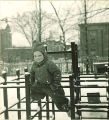 Small child climbing on a jungle gym in the snow, The University of Iowa, January 1938