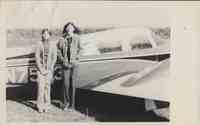 Two Women Standing Against Small Plane
