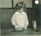 Girl working on a test using a battery, The University of Iowa, ca. 1920