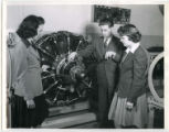 Professor Les Kelso instructing two cadettes about an airplane engine, 1943