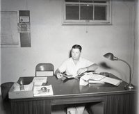 Unidentified Man Sits at Desk in Office