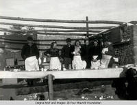 People standing behind table
