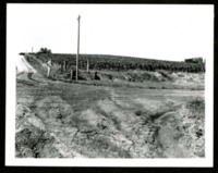 Man Stands by a Road Affected by Soil Erosion