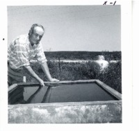 Tom Nielson with tank below pond