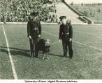 Men in uniform with "mascot" dog, The University of Iowa, 1929