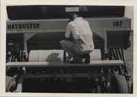 Man squats on Haybuster 107 seed drill