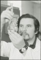 Researcher studying liquid in glassware, 1978