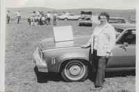 Woman Standing with Hand on Front of Car