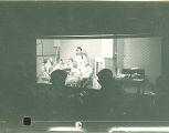 People observing a woman and girls working on crafts from an adjacent darkened room, The University of Iowa, October 28, 1938