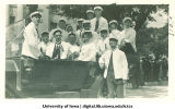 Students in white caps and jackets in parade for Senior Frolic, The University of Iowa, 1910s
