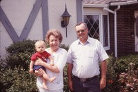 Bob and Joanne Lundquist with their grandson Levi in front of their home. 