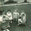 Woman reading to children outside, The University of Iowa, May 28, 1941