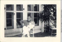 Man sitting in chair outside sun porch of White house