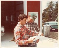 1970s Howard Bright and another man confer over a document that Howard is holding