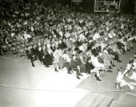 Alumni seated in folding chairs at the night before Homecoming Pep Rally, 1969