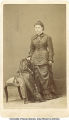 Woman standing by chair, La Porte City, Iowa, 1900s