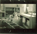 Small girl sitting in a wood box in playroom, The University of Iowa, January 12, 1938