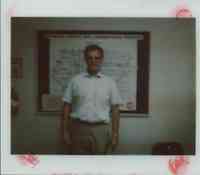 Unidentified Man in White Shirt Standing in Front of Map