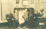 Family portrait against piano, Iowa, 1910s