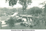 Commencement procession walking west across Iowa Avenue bridge with Old Capitol in background, The University of Iowa, 1920s