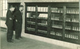 Students looking at a cabinet of  chemistry compounds, The University of Iowa, 1930s