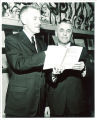 Looking at companion book to Philip D. Sang exhibition, left to right, Iowa Gov. Leo Hoegh and Philip D. Sang, The University of Iowa, 1956