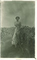 Woman standing in cornfield, Iowa, 1900s